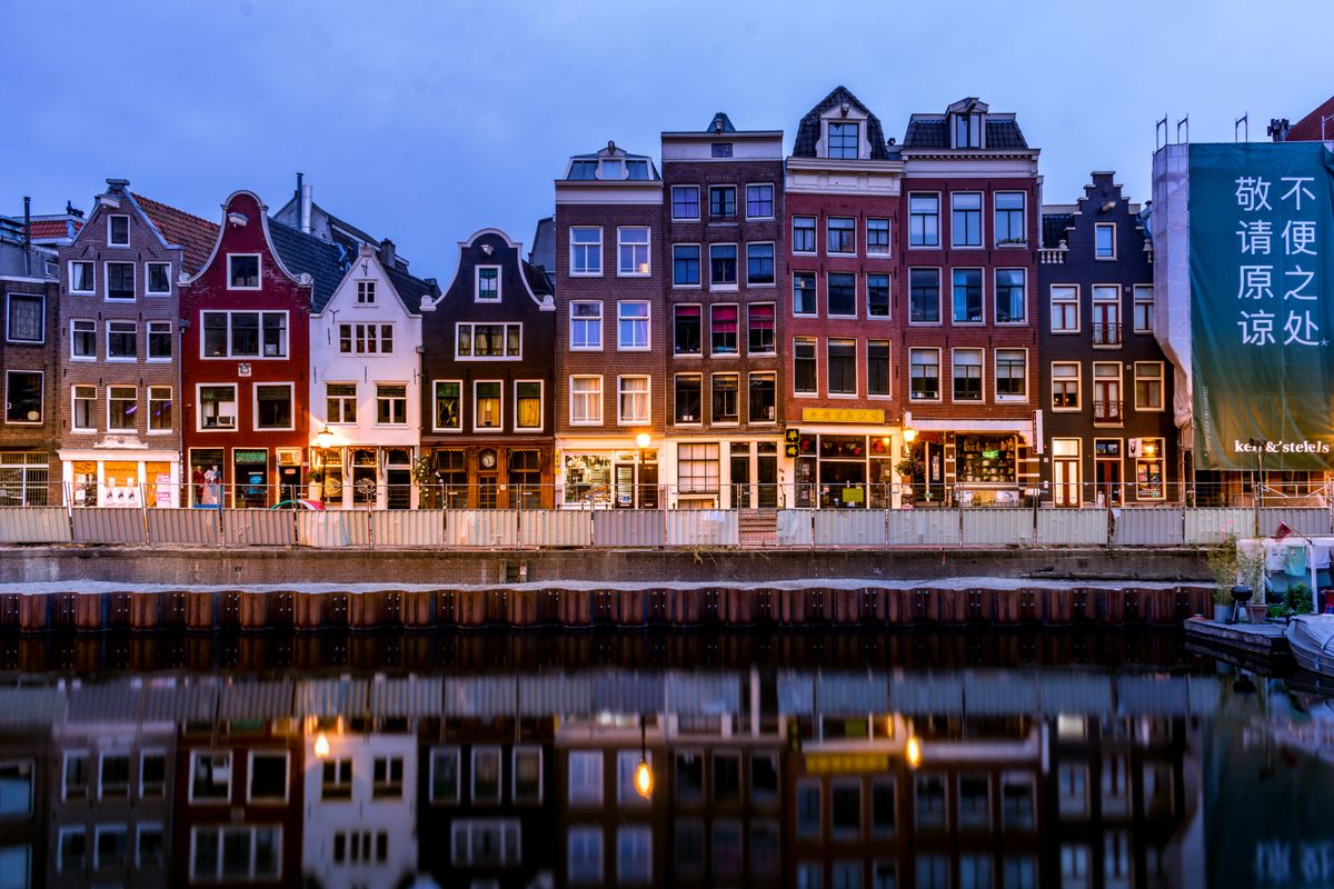 Amsterdamse grachtenpanden in het licht van de avondschemering