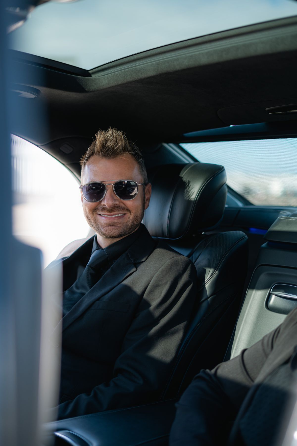 Passagier zit ontspannen in het verzorgde interieur van een Mercedes personenauto