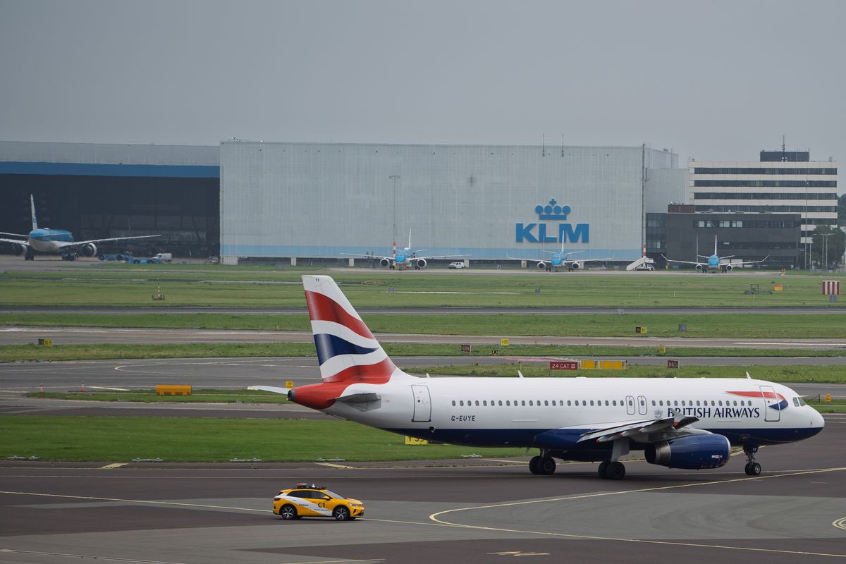 Vliegtuig taxiet langs een hangar op Amsterdam Airport Schiphol