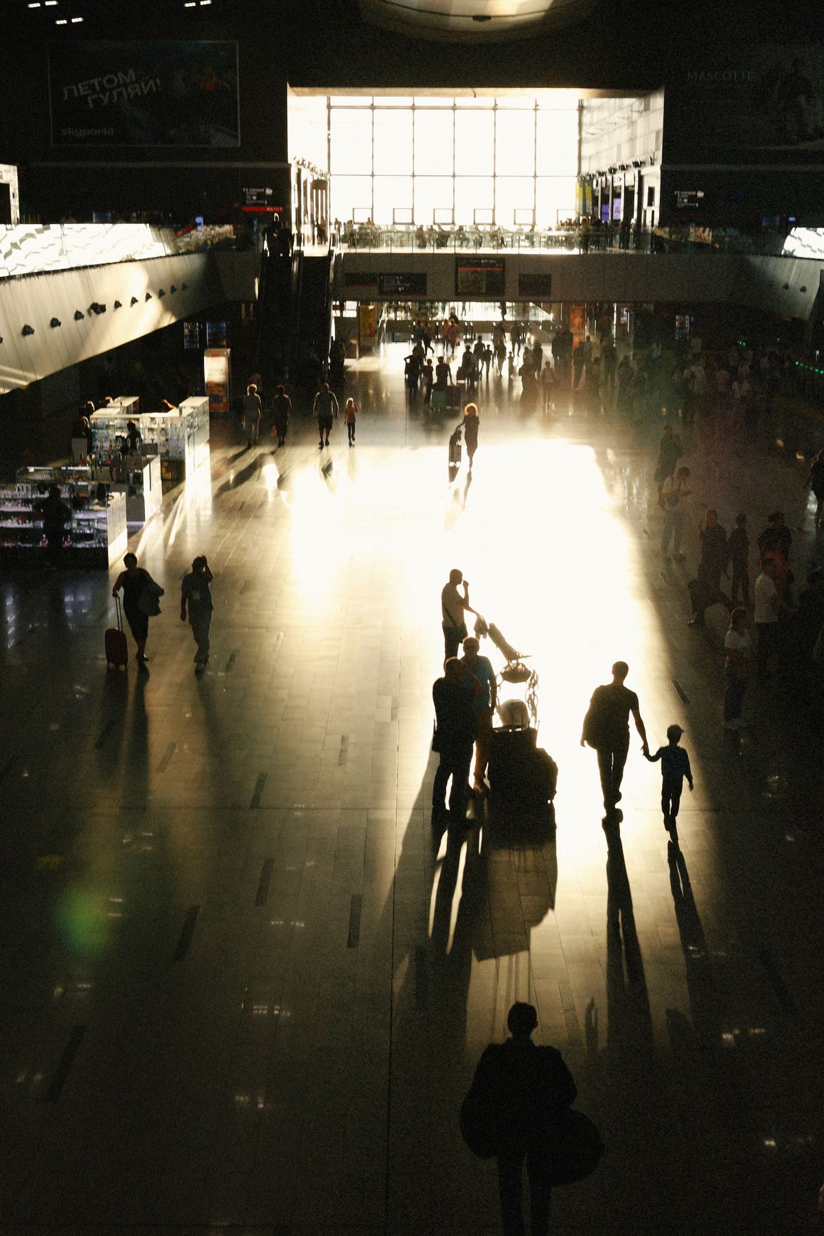 Reizigers lopen als silhouetten door een verlichte vertrekhal